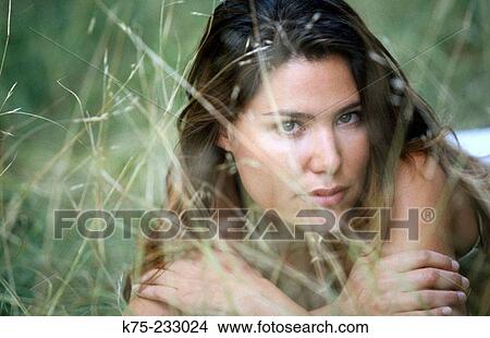 Woman peering through the grass View Large Photo Image Picture - Woman peering through the grass. Fotosearch