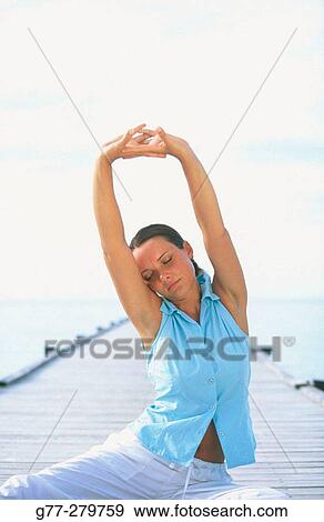 Stock Photo - Woman performing yoga in White Sands Resort and Spa. Ari Atoll, Maldives. Fotosearch