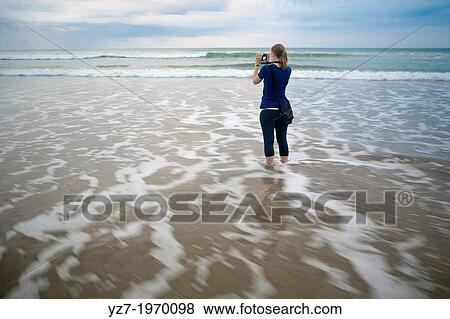 Woman photographing early morning at Santa Teresa beach, Costa Rica. View Large Photo Image Stock Photo - Woman photographing early morning at Santa Teresa beach, Costa Rica.. Fotosearch