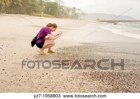 Woman photographing the surf on Playa Carmen, Costa Rica. View Large Photo Image Stock Image - Woman photographing the surf on Playa Carmen, Costa Rica.. Fotosearch