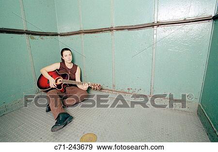 Woman playing a guitar inside a lift View Large Photo Image Stock Photo - Woman playing a guitar inside a lift. Fotosearch