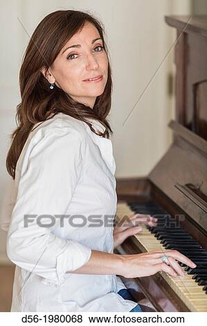 Woman playing a piano View Large Photo Image Stock Photo - Woman playing a piano. Fotosearch