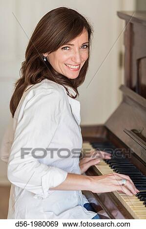 Woman playing a piano View Large Photo Image Stock Photo - Woman playing a piano. Fotosearch