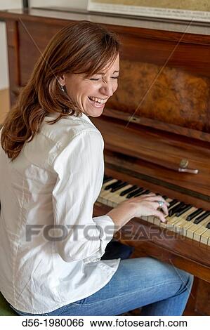 Woman playing a piano View Large Photo Image Stock Photograph - Woman playing a piano. Fotosearch