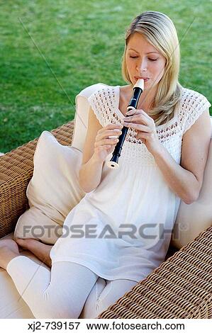 Woman playing the flute in the terrace View Large Photo Image Stock Photo - Woman playing the flute in the terrace. Fotosearch