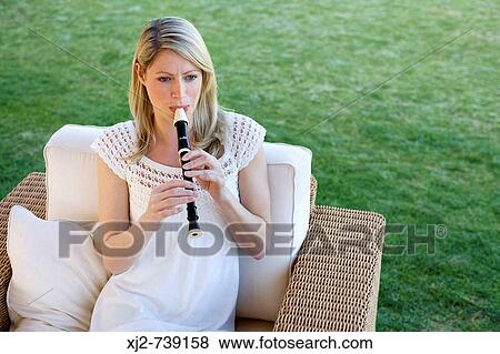 Woman playing the flute in the terrace View Large Photo Image Stock Photo - Woman playing the flute in the terrace. Fotosearch