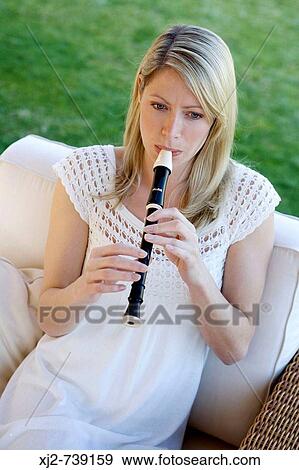 Woman playing the flute in the terrace View Large Photo Image Stock Photo - Woman playing the flute in the terrace. Fotosearch