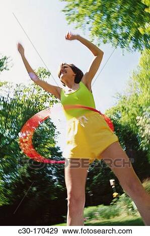 Stock Photo - Woman playing with hula-hoop. Fotosearch