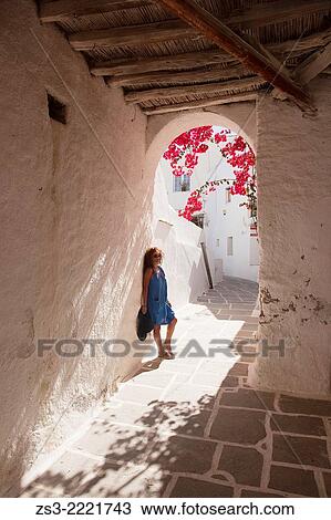 Woman posing at a passageway in town center Chora, Ios, Cyclades Islands, Greek Islands, Greece, Europe. View Large Photo Image Stock Image - Woman posing at a passageway in town center Chora, Ios, Cyclades Islands, Greek Islands, Greece, Europe.. Fotosearch