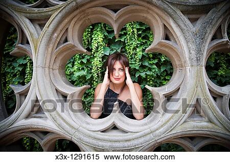 Stock Photography - Woman posing by sculpture Hotel de Sully Paris France. Fotosearch