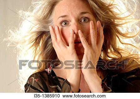 Stock Image - Woman posing in the studio with strong light behind. Fotosearch