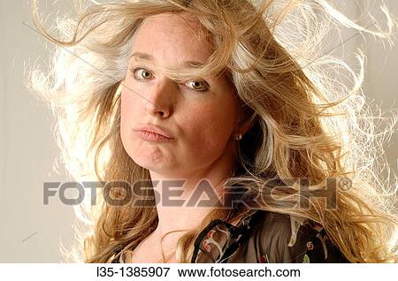 Stock Photo - Woman posing in the studio with strong light behind. Fotosearch