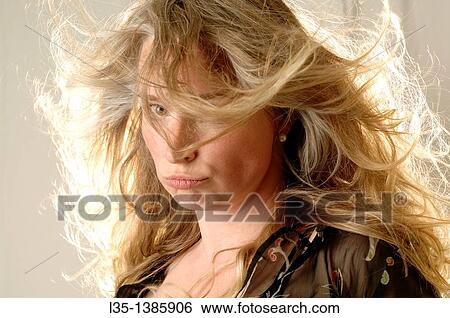 Stock Photograph - Woman posing in the studio with strong light behind. Fotosearch