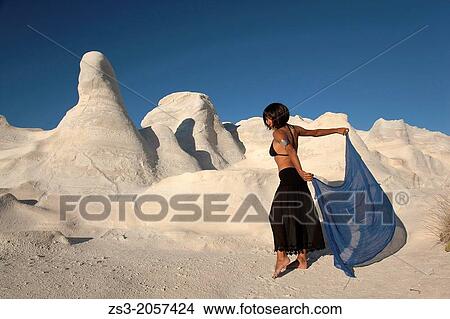 Woman posing near the white rock forms in Sarakiniko beach, Milos, Cyclades Islands, Greek Islands, Greece, Europe. View Large Photo Image Picture - Woman posing near the white rock forms in Sarakiniko beach, Milos, Cyclades Islands, Greek Islands, Greece, Europe.. Fotosearch