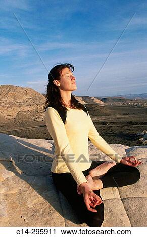 Stock Image - Woman practicing yoga at Snow Canyon State Park. Utah, USA. Fotosearch