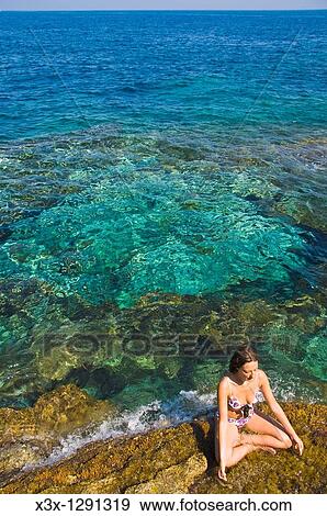 Woman practicing yoga on the Pantelleria island coast, Sicily, Italy View Large Photo Image Stock Photo - Woman practicing yoga on the Pantelleria island coast, Sicily, Italy. Fotosearch