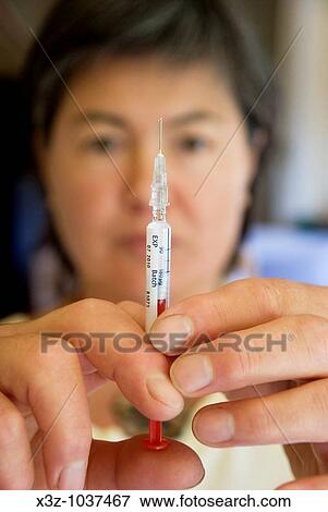 Woman preparing a dose of Interferon for self administration by hypodermic needle View Large Photo Image Stock Photo - Woman preparing a dose of Interferon for self administration by hypodermic needle. Fotosearch