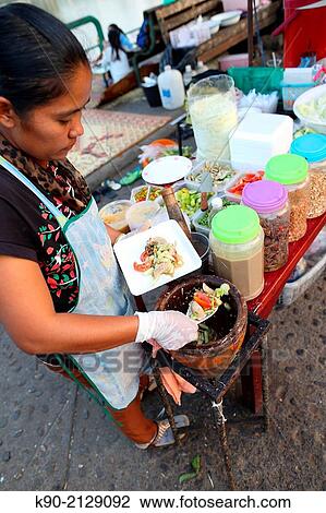 Woman preparing fresh papaya salad and filling it on a plate, Mae Hong Son, Thailand, Southeast Asia. View Large Photo Image Stock Image - Woman preparing fresh papaya salad and filling it on a plate, Mae Hong Son, Thailand, Southeast Asia.. Fotosearch