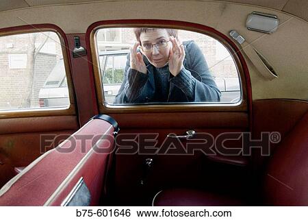 Woman prying in an old car View Large Photo Image Stock Photograph - Woman prying in an old car. Fotosearch