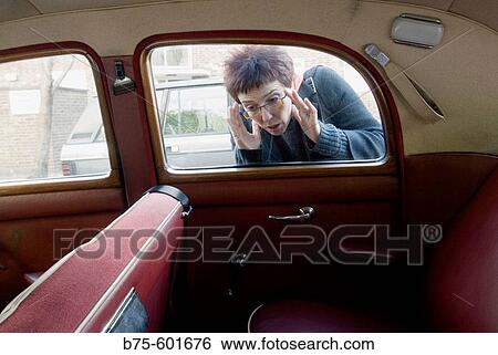Woman prying in an old car View Large Photo Image Stock Photograph - Woman prying in an old car. Fotosearch
