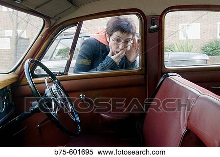 Woman prying in an old car View Large Photo Image Stock Photography - Woman prying in an old car. Fotosearch
