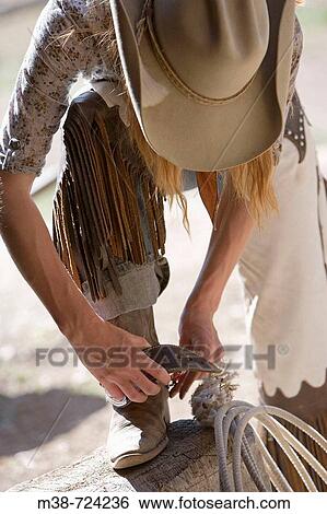 Woman putting on spurs, Lone Mt Ranch, Big Sky, Montana, USA View Large Photo Image Stock Photograph - Woman putting on spurs, Lone Mt Ranch, Big Sky, Montana, USA. Fotosearch