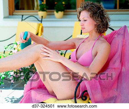 Woman putting on suntan lotion View Large Photo Image Stock Image - Woman putting on suntan lotion. Fotosearch