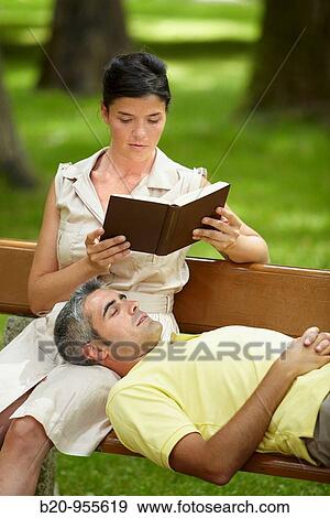 Woman reading a book and man in a garden, spa-relais. Lierganes hotel and spa, Cantabria, Spain View Large Photo Image Stock Photo - Woman reading a book and man in a garden, spa-relais. Lierganes hotel and spa, Cantabria, Spain. Fotosearch
