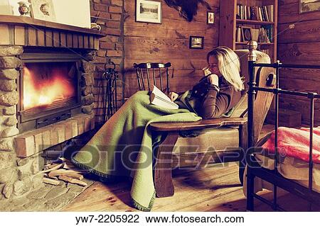 Woman reading a book in front of chimney. View Large Photo Image Stock Image - Woman reading a book in front of chimney.. Fotosearch