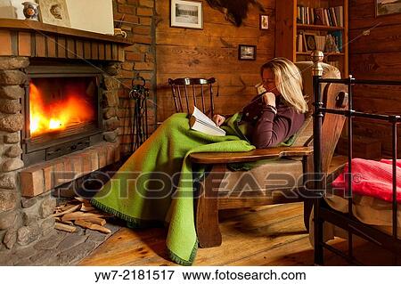 Woman reading a book in front of chimney. View Large Photo Image Stock Photo - Woman reading a book in front of chimney.. Fotosearch