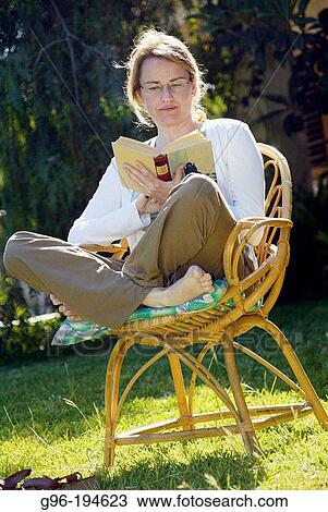 Woman reading a book in the garden View Large Photo Image Stock Image - Woman reading a book in the garden. Fotosearch