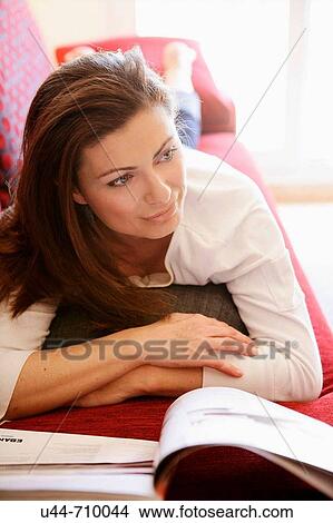 Woman reading a book relaxed on the sofa View Large Photo Image Picture - Woman reading a book relaxed on the sofa. Fotosearch