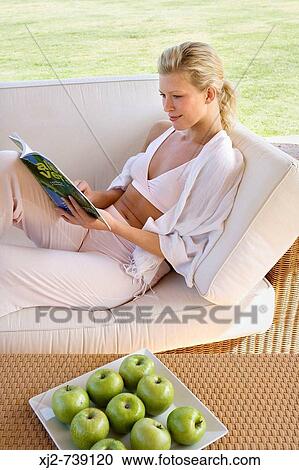 Woman reading a magazine at home outdoors View Large Photo Image Stock Image - Woman reading a magazine at home outdoors. Fotosearch
