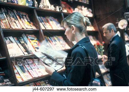 Woman reading a magazine in a book store View Large Photo Image Stock Photo - Woman reading a magazine in a book store. Fotosearch