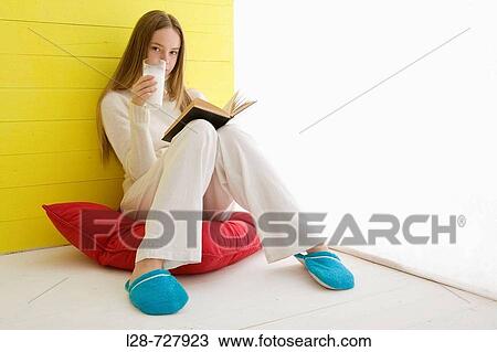 Woman reading book and drinking milk View Large Photo Image Stock Image - Woman reading book and drinking milk. Fotosearch