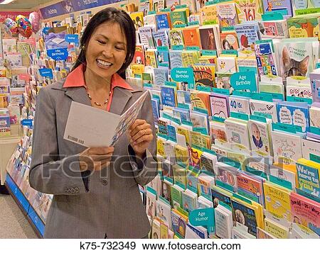 Woman reading greeting card in store View Large Photo Image Stock Photo - Woman reading greeting card in store. Fotosearch