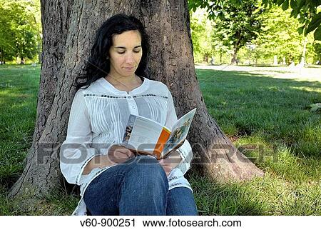 Stock Image - Woman reading, Kengsinton Gardens, London. Fotosearch