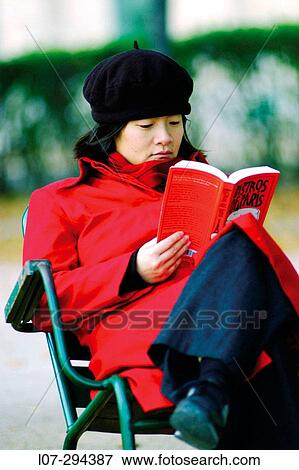 Stock Photo - Woman reading red? bistro? guide book in Tuileries gardens. Paris. France. Fotosearch