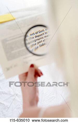 Woman reads a contract fine prints using a magnifier says act of God and deposit View Large Photo Image Stock Image - Woman reads a contract fine prints using a magnifier says act of God and deposit. Fotosearch
