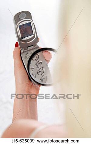 Woman reads the cell phone keys using a magnifier View Large Photo Image Stock Photo - Woman reads the cell phone keys using a magnifier. Fotosearch