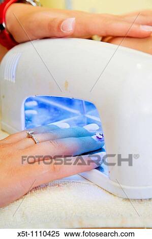 Woman receiving manicure, drying the nail polish View Large Photo Image Stock Photography - Woman receiving manicure, drying the nail polish. Fotosearch
