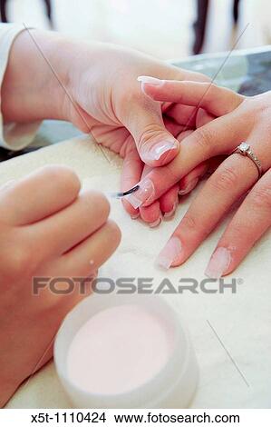 Woman receiving manicure, nail polish is applied, close-up View Large Photo Image Picture - Woman receiving manicure, nail polish is applied, close-up. Fotosearch