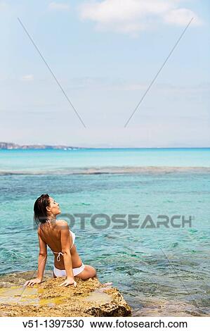Stock Image - Woman relaxing in a beach in Formentera, Balearic Islands, Spain. Fotosearch