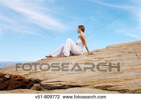 Woman relaxing in a cliff by the sea View Large Photo Image Stock Image - Woman relaxing in a cliff by the sea. Fotosearch