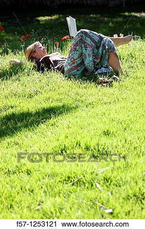 Woman relaxing in the grass View Large Photo Image Stock Image - Woman relaxing in the grass. Fotosearch