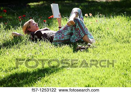 Woman relaxing in the grass View Large Photo Image Stock Image - Woman relaxing in the grass. Fotosearch
