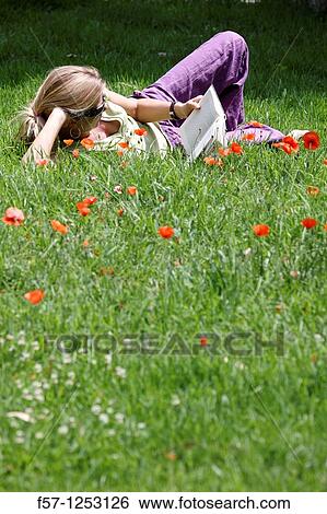 Stock Photograph - Woman relaxing in the grass. Fotosearch