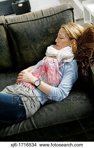 Picture - Woman relaxing on coach. Fotosearch