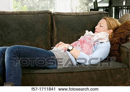 Woman relaxing on coach View Large Photo Image Stock Image - Woman relaxing on coach. Fotosearch