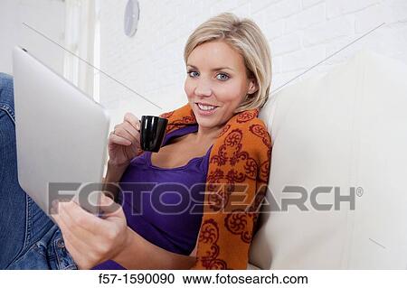 Woman relaxing on her bed with her tablet computer View Large Photo Image Stock Image - Woman relaxing on her bed with her tablet computer. Fotosearch